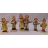 Five Hummel figurines of children in various poses some playing musical instruments, marks to the