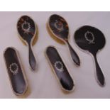 A hallmarked silver and tortoiseshell dressing table set to include a hand mirror, two hair