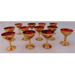 Twelve Murano champagne glasses with applied gilding and flowers on circular spreading bases