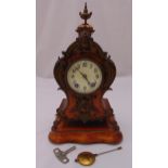 A continental wooden and brass mantle clock, white enamel dial, Arabic numerals, two train