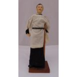 A carved hand painted wooden figurine of a vicar in religious garb, 43cm (h)