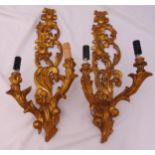 A pair of carved gilded wooden wall brackets supporting two lights, 61cm (h)
