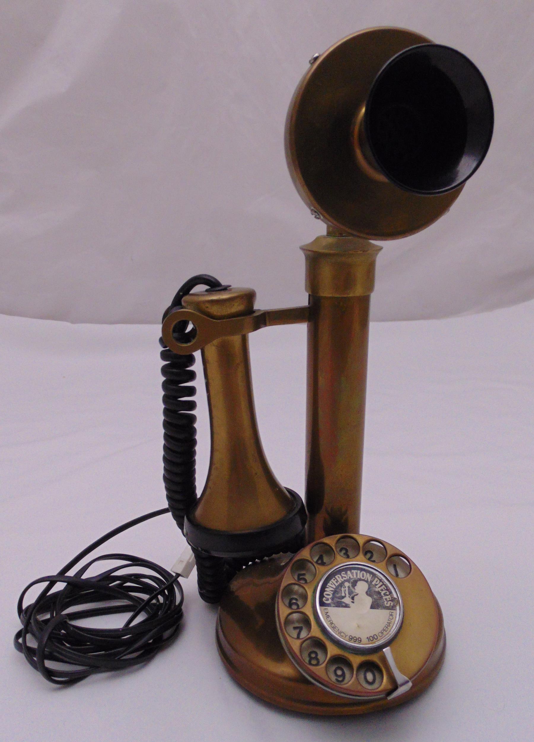 A reproduction brass and black plastic stick telephone