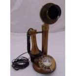 A reproduction brass and black plastic stick telephone