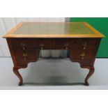 A late 19th century rectangular oak kneehole desk with four drawers, brass handles and tooled