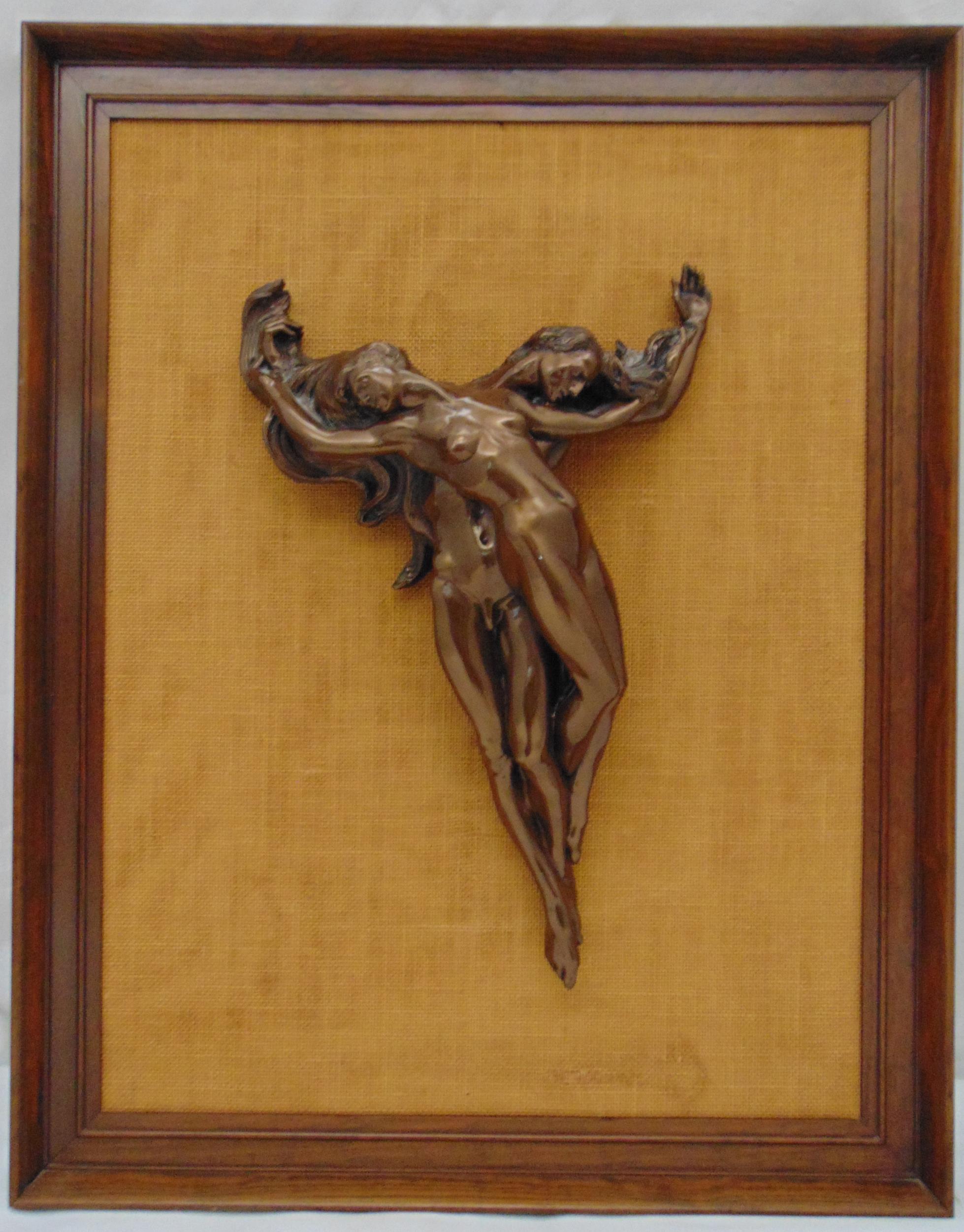 A bronze erotic figurine of an entwined male and female, mounted on hessian in rectangular wooden