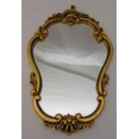 A gilded gesso shaped oval wall mirror, 67.5 x 42.5cm