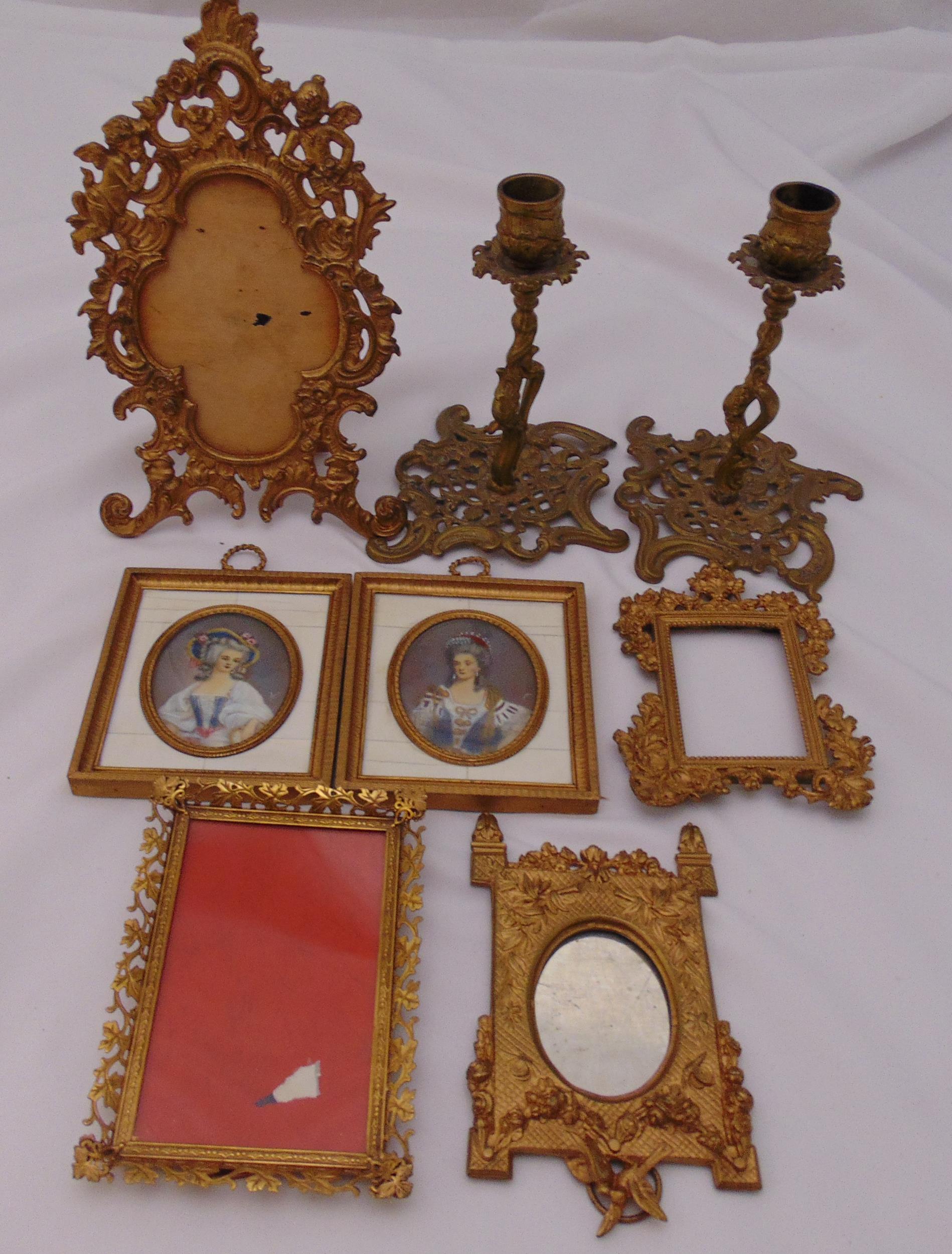 A quantity of gilded metal frames, a pair of table candlesticks and two framed miniatures (8)