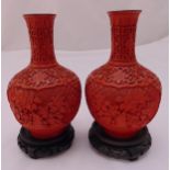 A pair of cinnabar lacquer baluster vases carved with stylised flowers and leaves on circular