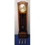 An Art Deco oak longcase clock with silvered dial and Arabic numerals, hinged glazed front on