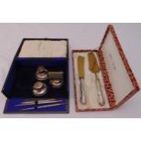 A hallmarked silver cased pen and inkwell set and a cased set of white metal and brass servers
