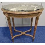 A French oval gilded wooden side table with detachable marble top on four fluted tapering circular