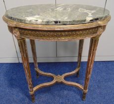 A French oval gilded wooden side table with detachable marble top on four fluted tapering circular