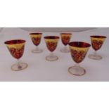 A set of six Murano red glasses with gilding on raised circular stems