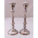 A pair of hallmarked silver table candlesticks of knopped cylindrical form on raised circular bases,