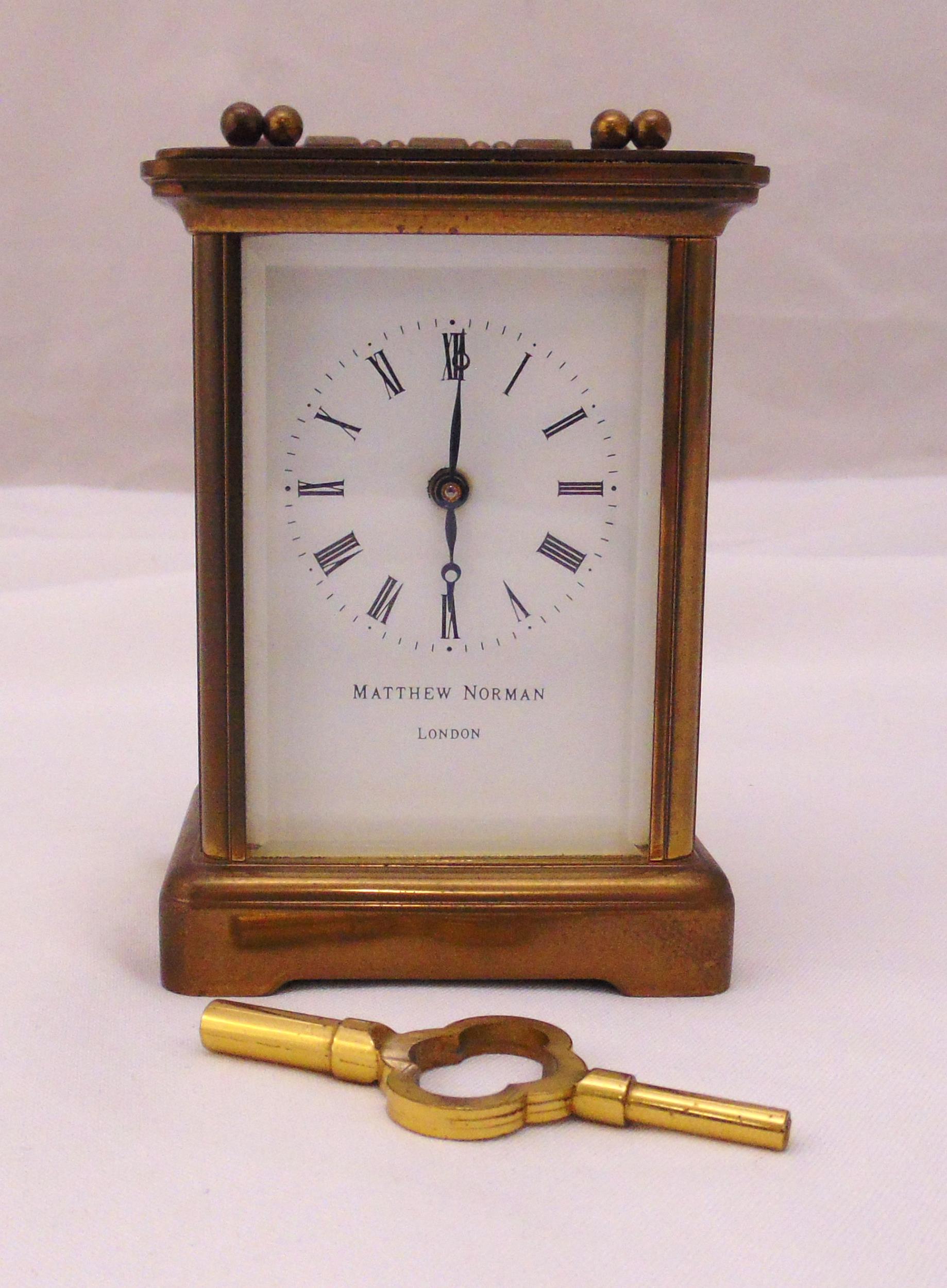 Matthew Norman brass carriage clock of customary form, white enamel dial and Roman numerals, to