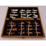 A composition chess set with oriental characters in fitted wooden case
