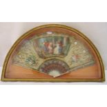 A framed and glazed French silk fan with classical scenes between floral sprays and scroll pierced