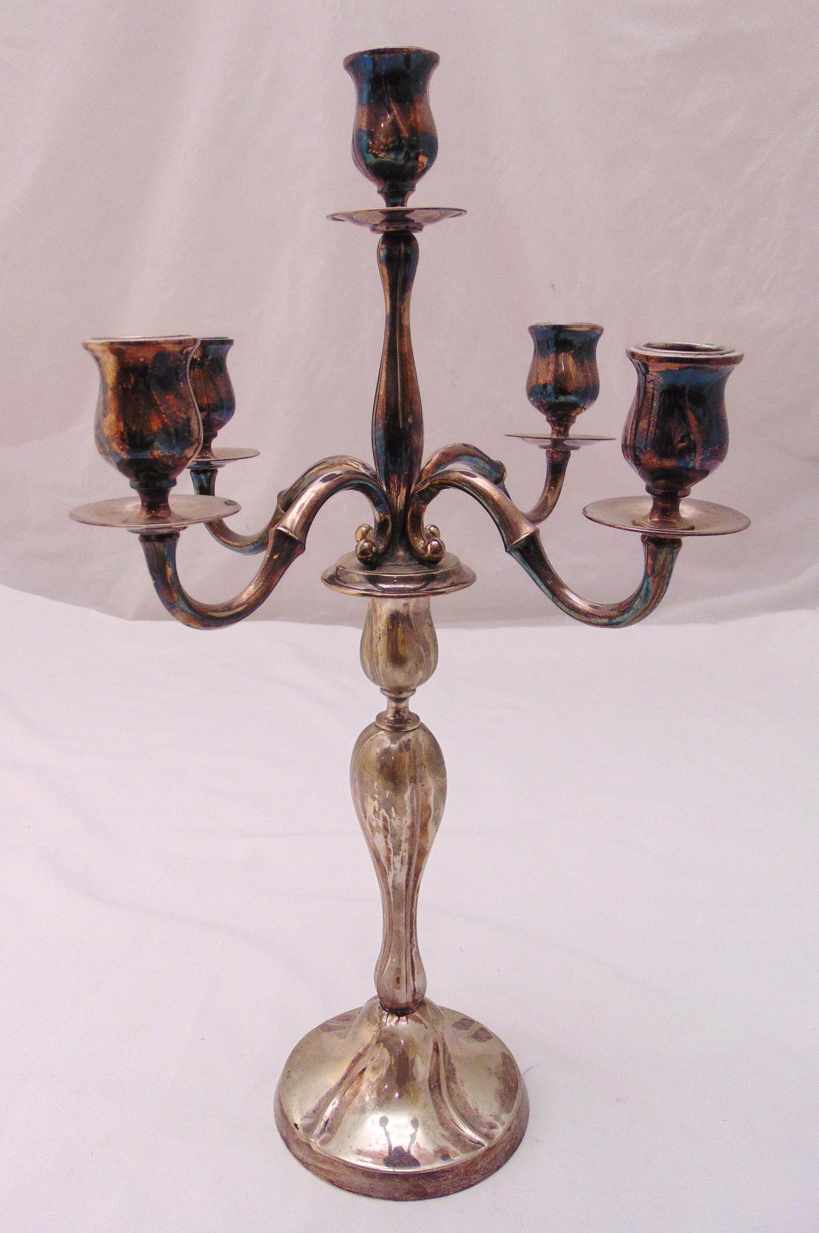 A continental white metal five light candelabrum stamped 800 with scroll arms on raised circular