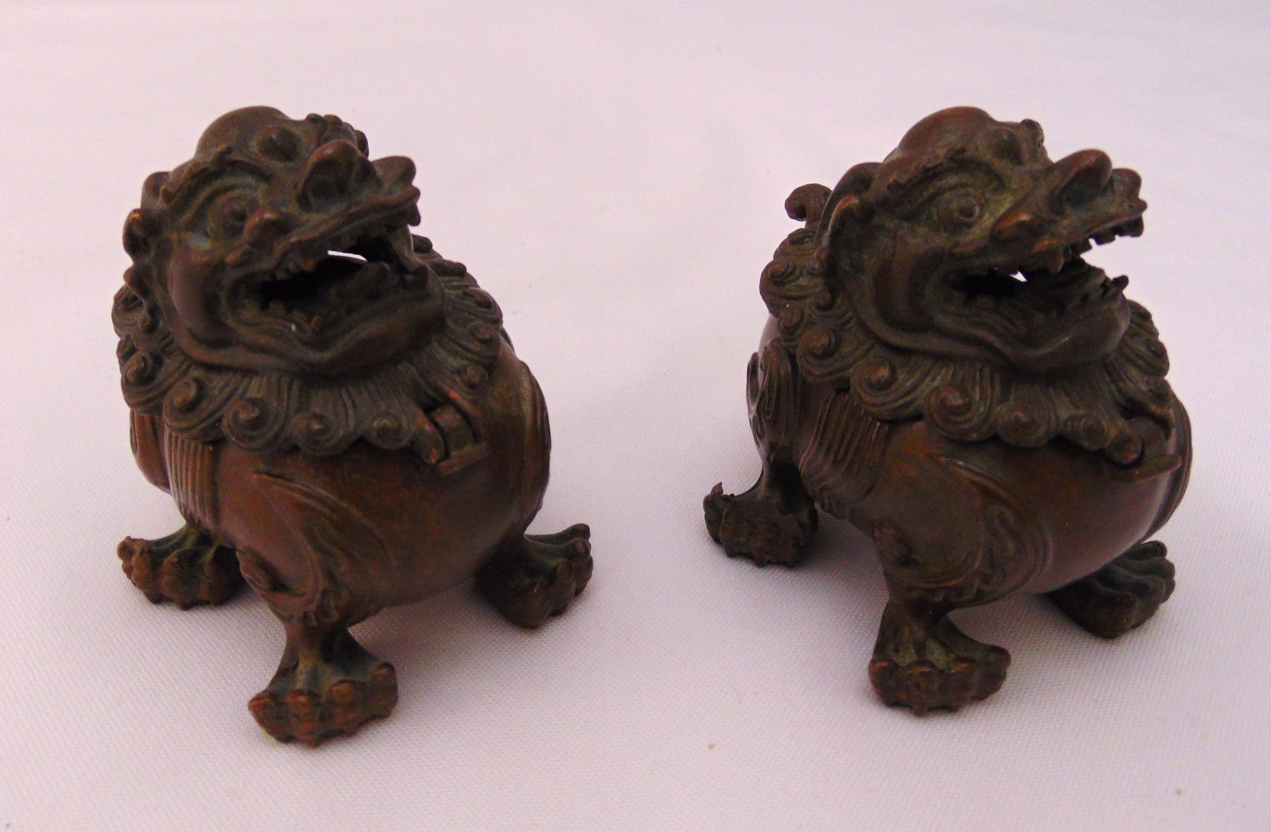 A pair of Chinese bronze incense burners in the form of stylised temple lions with hinged mask