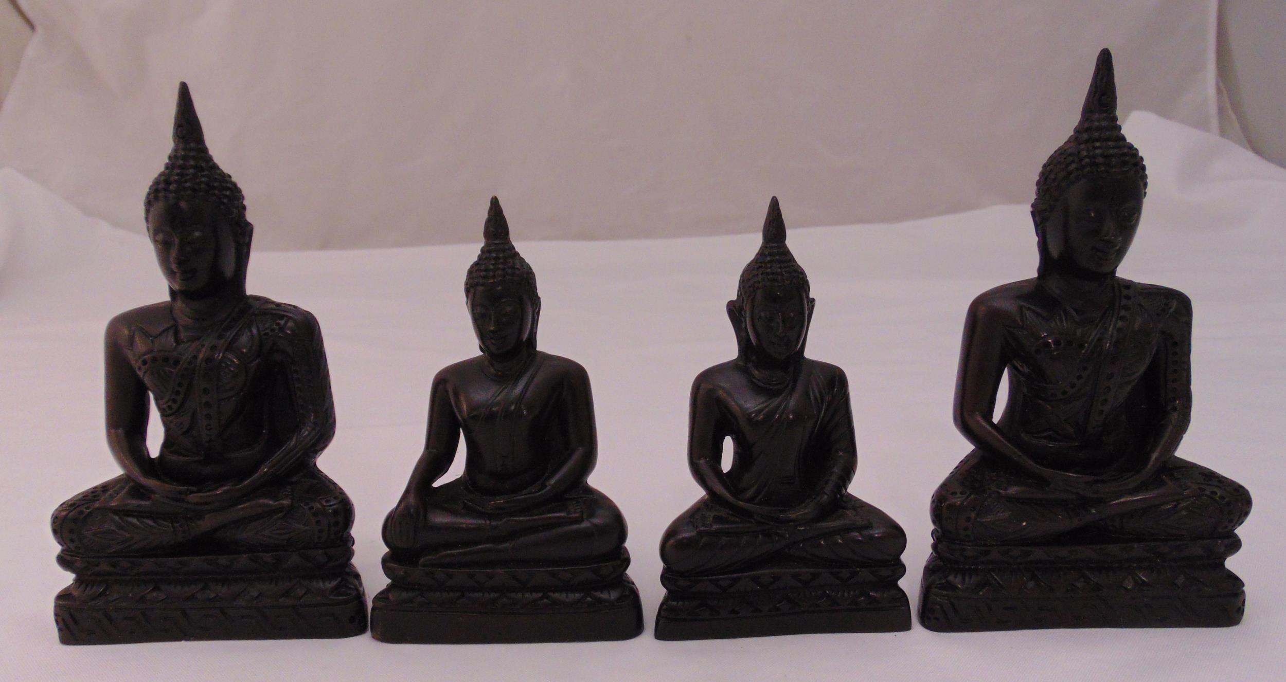 Four oriental carved wooden meditating Buddhas on raised shaped rectangular bases, 16.5cm (h)