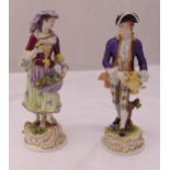 Two continental figurines of a man holding a ewer and lady holding flowers in her apron on raised