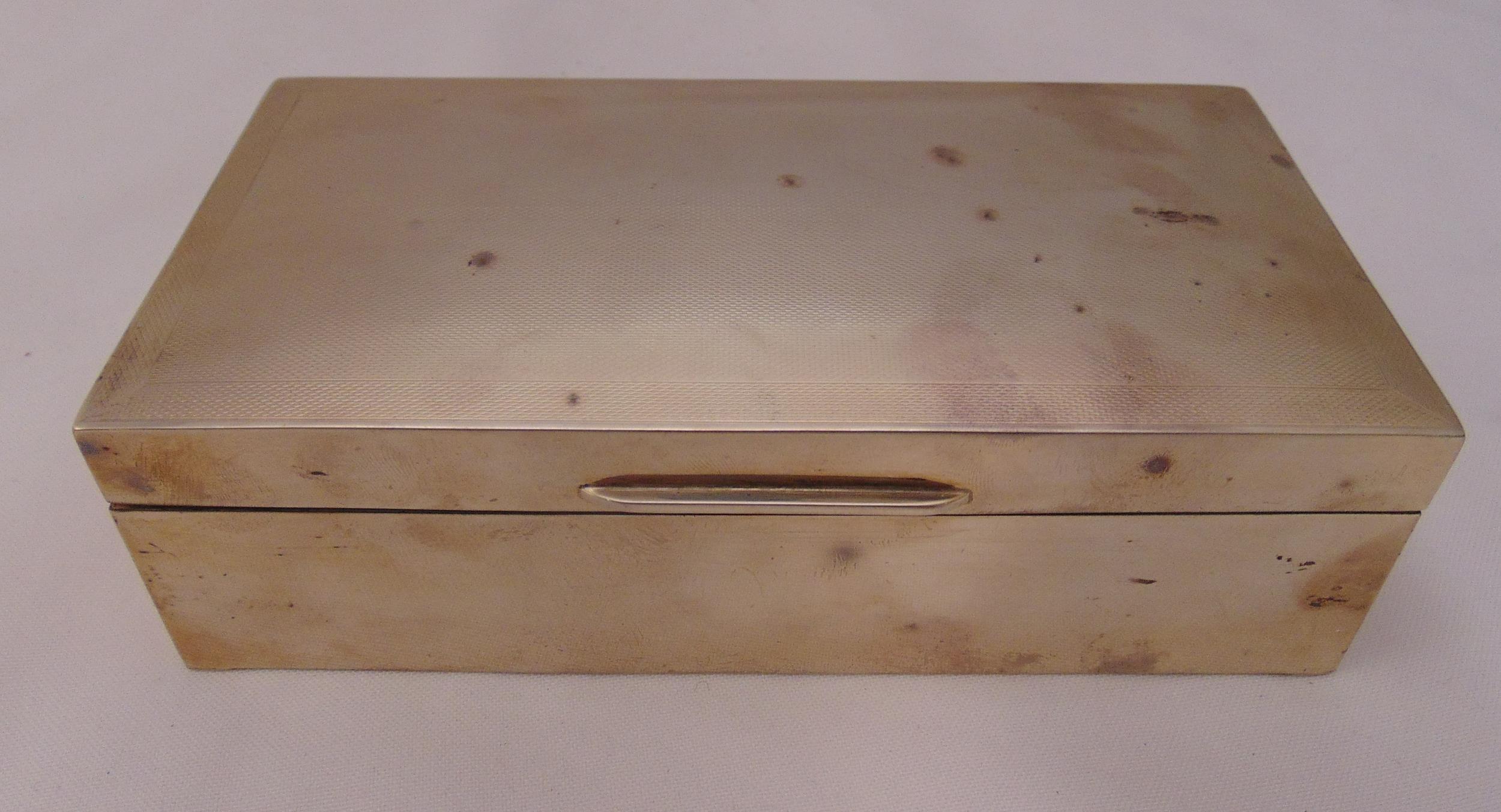 A hallmarked silver rectangular engine turned cigarette box, cedar wood lining, Birmingham 1955,