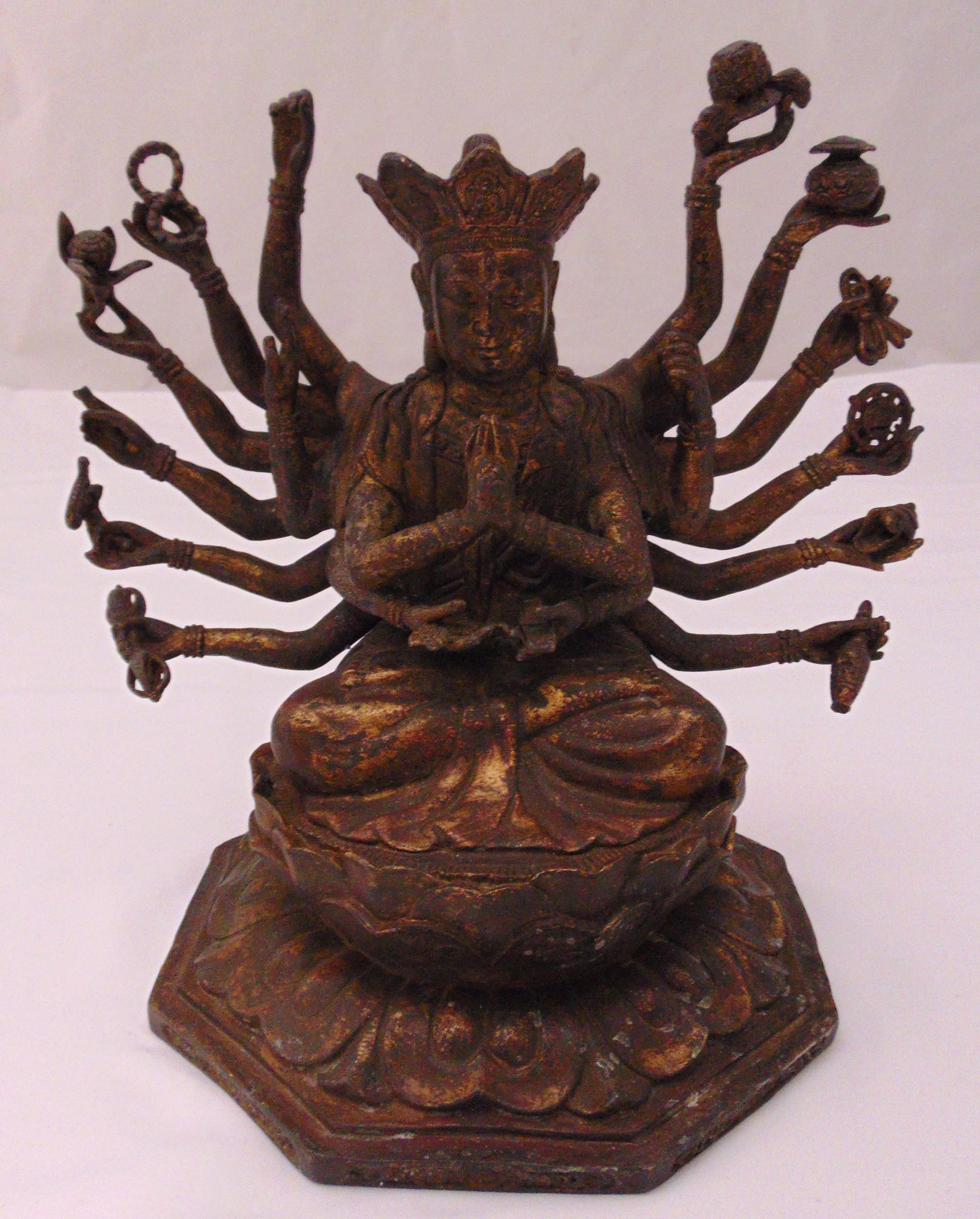 A Chinese bronze figurine of a multi handed Buddha on octagonal base, 27cm (h)