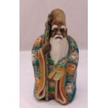 A Chinese 19th century figurine of an elder with white beard and polychromatic gown, 30cm (h)