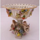 A continental comport on raised base with applied putti, flowers and fruit, marks to the base,