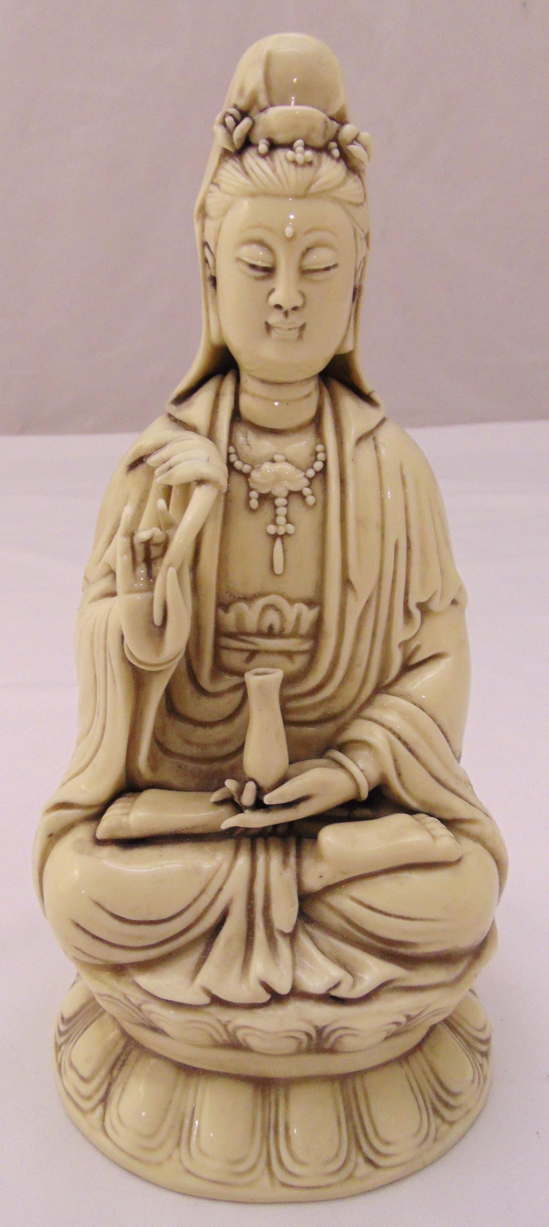 A Chinese ceramic seated figurine of Guanyin on raised shaped base, 26cm (h)