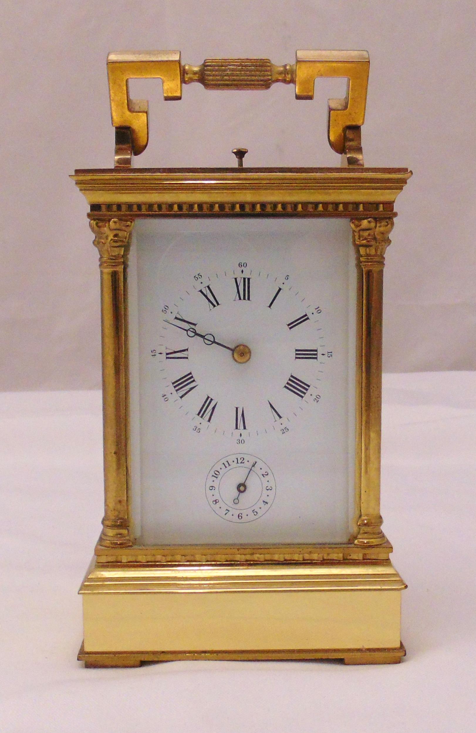 A gilt metal repeating carriage clock, architectural form, white dial with Roman numerals with