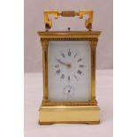 A gilt metal repeating carriage clock, architectural form, white dial with Roman numerals with