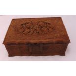 A Black Forest rectangular carved wooden jewellery casket with hinged cover and secret drawer to