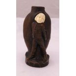 A bronze figurine of a boy standing next to a vase, indistinctly signed to the base, 11cm (h)