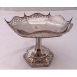 A hallmarked silver fruit stand with pierced hexagonal shaped border on raised scroll pierced