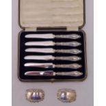 A cased set of six hallmarked silver cake knives with hallmarked silver handles and two bottle