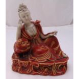 A Chinese ceramic copper red glazed Guanyin recumbent Buddha and stylised lion on raised oval