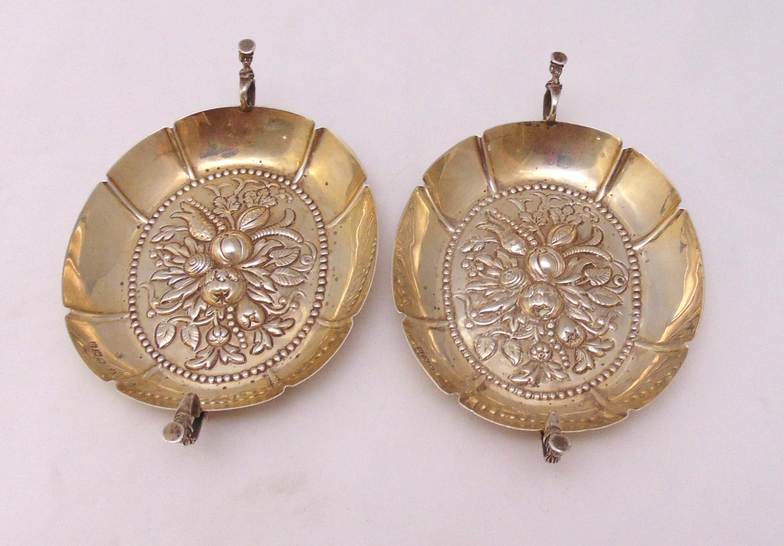 A pair of Victorian hallmarked silver wine tasters of oval form with two scroll handles, chased to