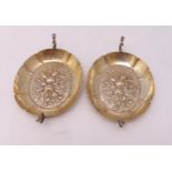 A pair of Victorian hallmarked silver wine tasters of oval form with two scroll handles, chased to