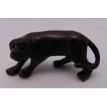 A Japanese netsuke in the form of a carved boxwood tiger, 5cm (w)