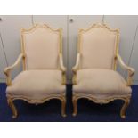 A pair of antique painted upholstered open armchairs in Louis XV style