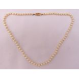 A string of well matched cultured pearls with gold clasp