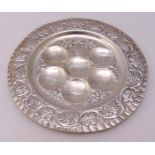 A white metal Pesach plate of customary form with scroll, leaf and berry chased everted border