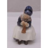 A Royal Copenhagen figurine of an Amager girl knitting, marks to the base, 15.5 cm (h)