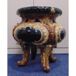 A 19th century majolica garden seat compressed circular on four scroll supports, possibly by