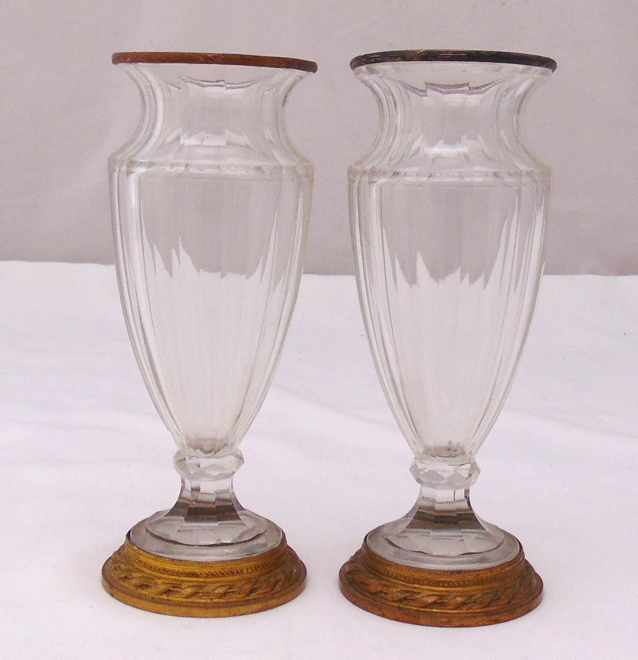 A pair of early 20th century glass vases with gilt metal collars and raised circular bases, 20cm (