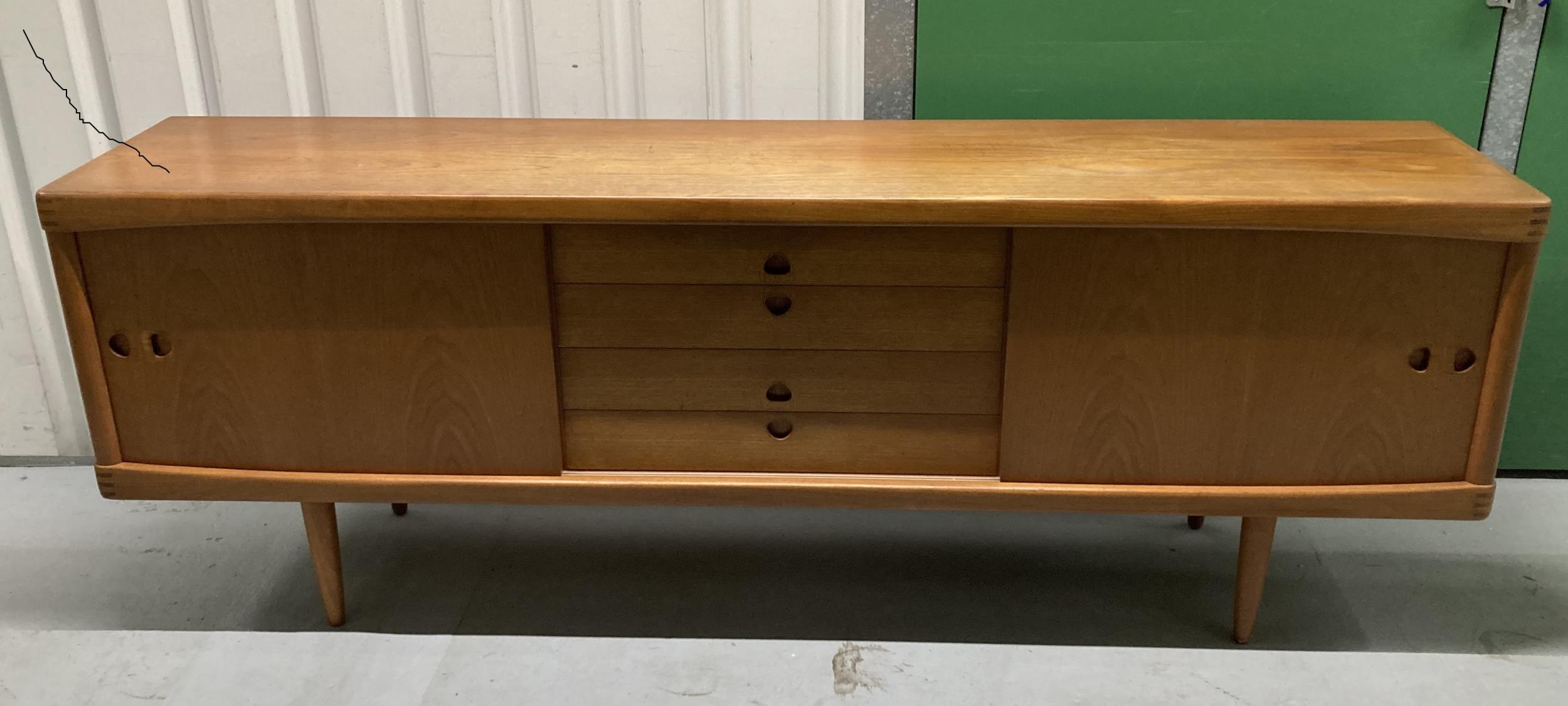 A mid 20th century rectangular teak sideboard with cupboards and drawers on four tapering