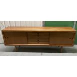 A mid 20th century rectangular teak sideboard with cupboards and drawers on four tapering