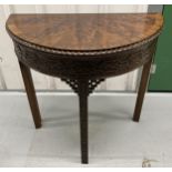 A mahogany demilune games table with pierced and carved rectangular legs, the hinged cover with